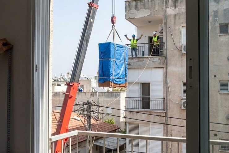 מנוף מרים ריהוט עטוף לעבר מרפסת בקומה גבוהה