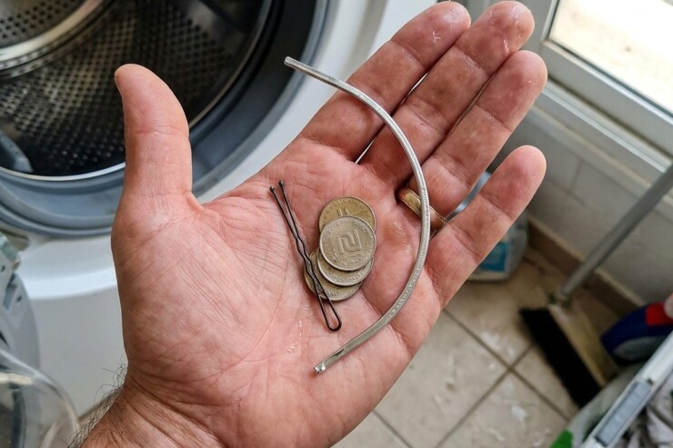 מטבעות, סיכה וחוט מתכת מחזייה שנמצאו בתוך מכונת כביסה מרעישה
